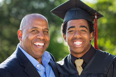 A father with his son, who is dressed in a grad cap and gown